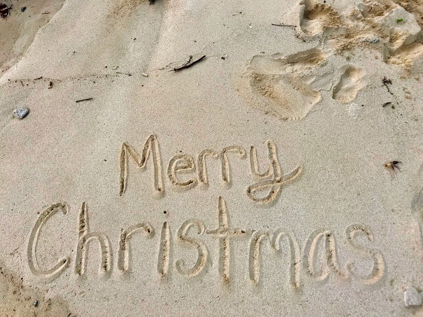 Merry Christmas written in the sand